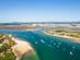 Aerial view of the islands and islets off the coast of the Algarve with a flotilla of boats sailing between the Ria Formosa Natural Park and Tavira Island