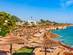 A busy beach resort in Sharm el Sheikh with lots of thatched umbrellas and sun loungers lining the sand