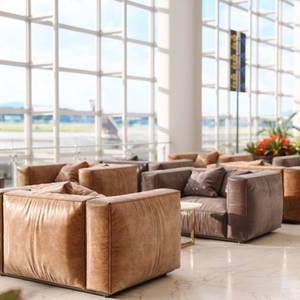Close-up view of brown leather armchairs at an airport lounge