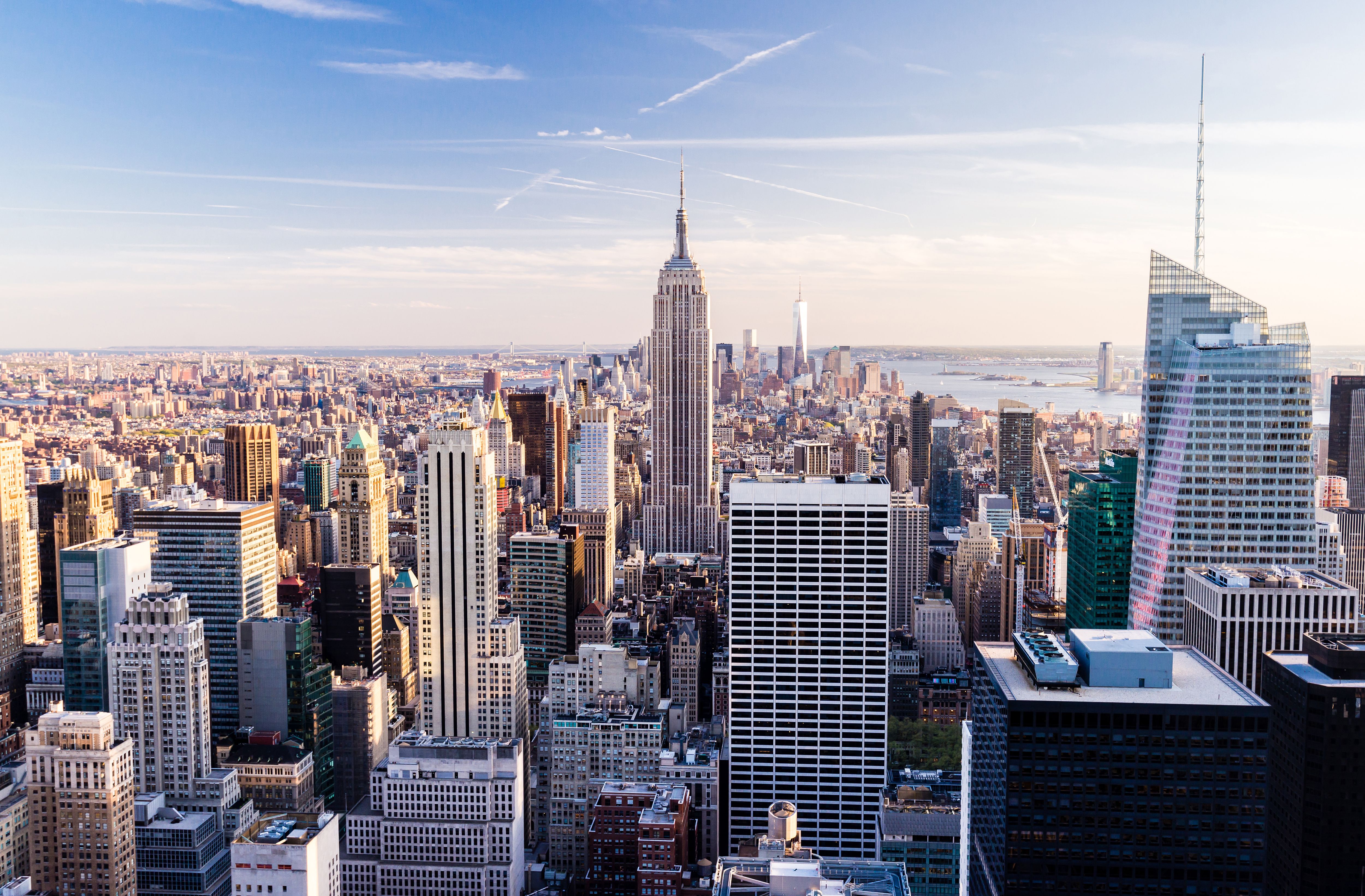 A skyline view of the Empire State Building and Manhattan skyscrapers as the sun rises