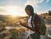 Woman with backpack looking at smart phone while hiking in Red Rock Canyon Nevada