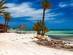 A view of the Mediterranean coast with white sand beach and palm trees in Djerba, Tunisia