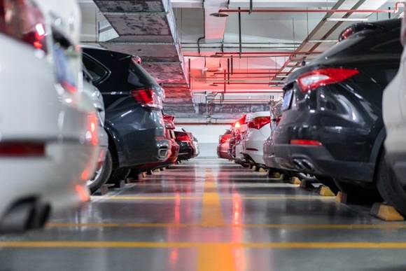 A picture showing numerous cars parked in airport parking lot at an airport