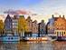 The crooked 'Dancing Houses' in traditional Amsterdam style along the Damrak canal in Amsterdam at sunset