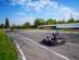 Racer driving a go-kart on an outdoor race track on a bright sunny day