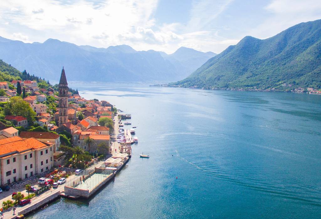 An aerial view of Perast and Kotor bay in Montenegro with dazzling blue water and lush green mountains