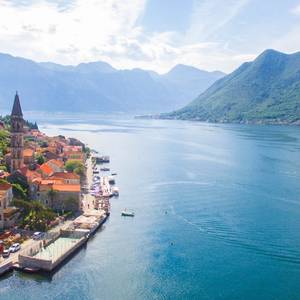 An aerial view of Perast and Kotor bay in Montenegro with dazzling blue water and lush green mountains