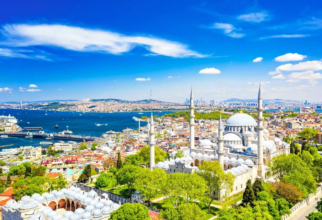 Aerial view of the Suleymaniye Mosque, with its domed roof and spiky minarets, and Istanbul's Golden Horn waterway in the background
