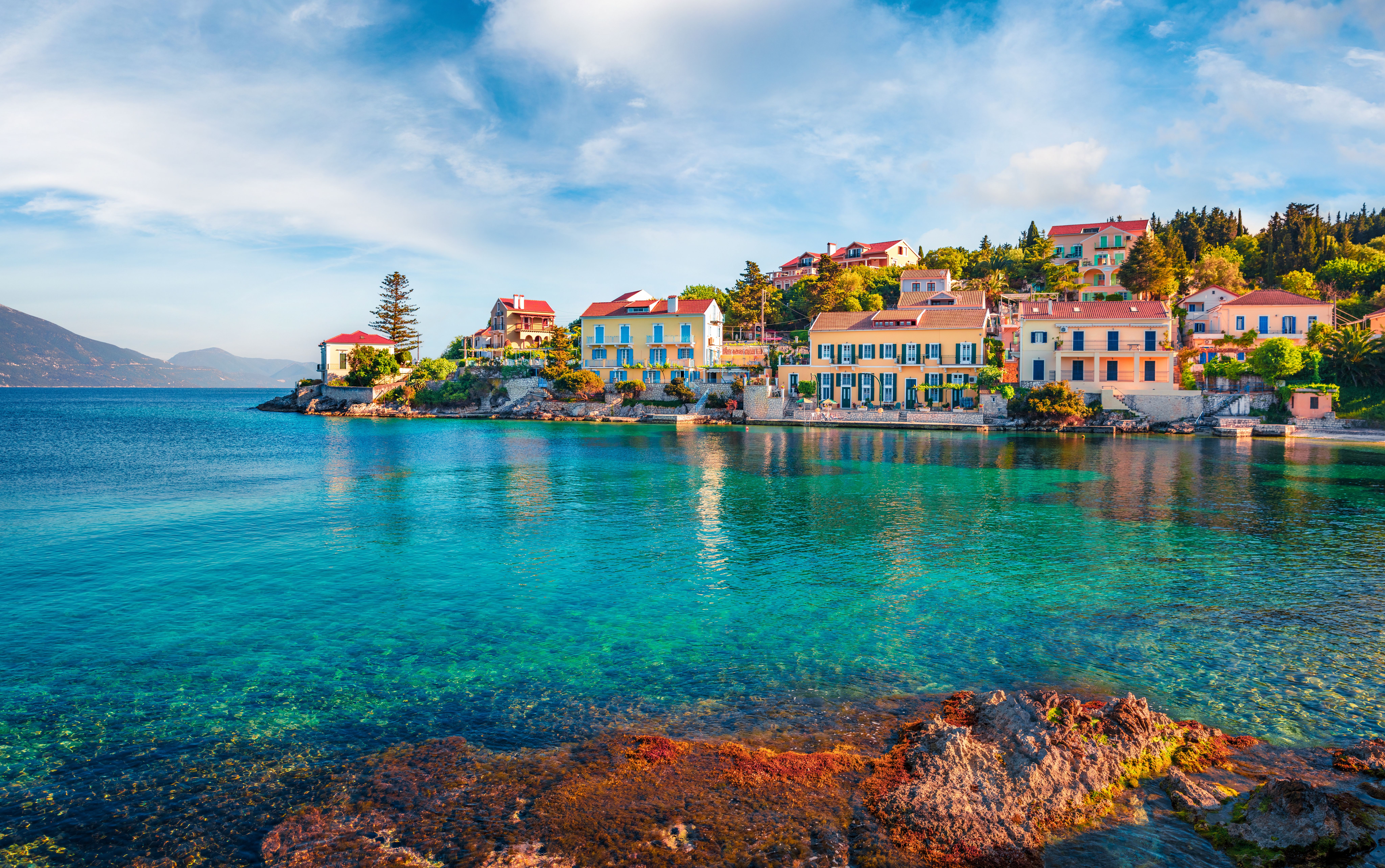 View across clear, aquamarine waters towards the colourful town of Fiskardo
