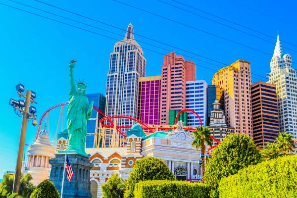 A city view of downtown Las Vegas showing the replica Statue of Liberty and New York cityscape of colourful high-rise buildings on a sunny day