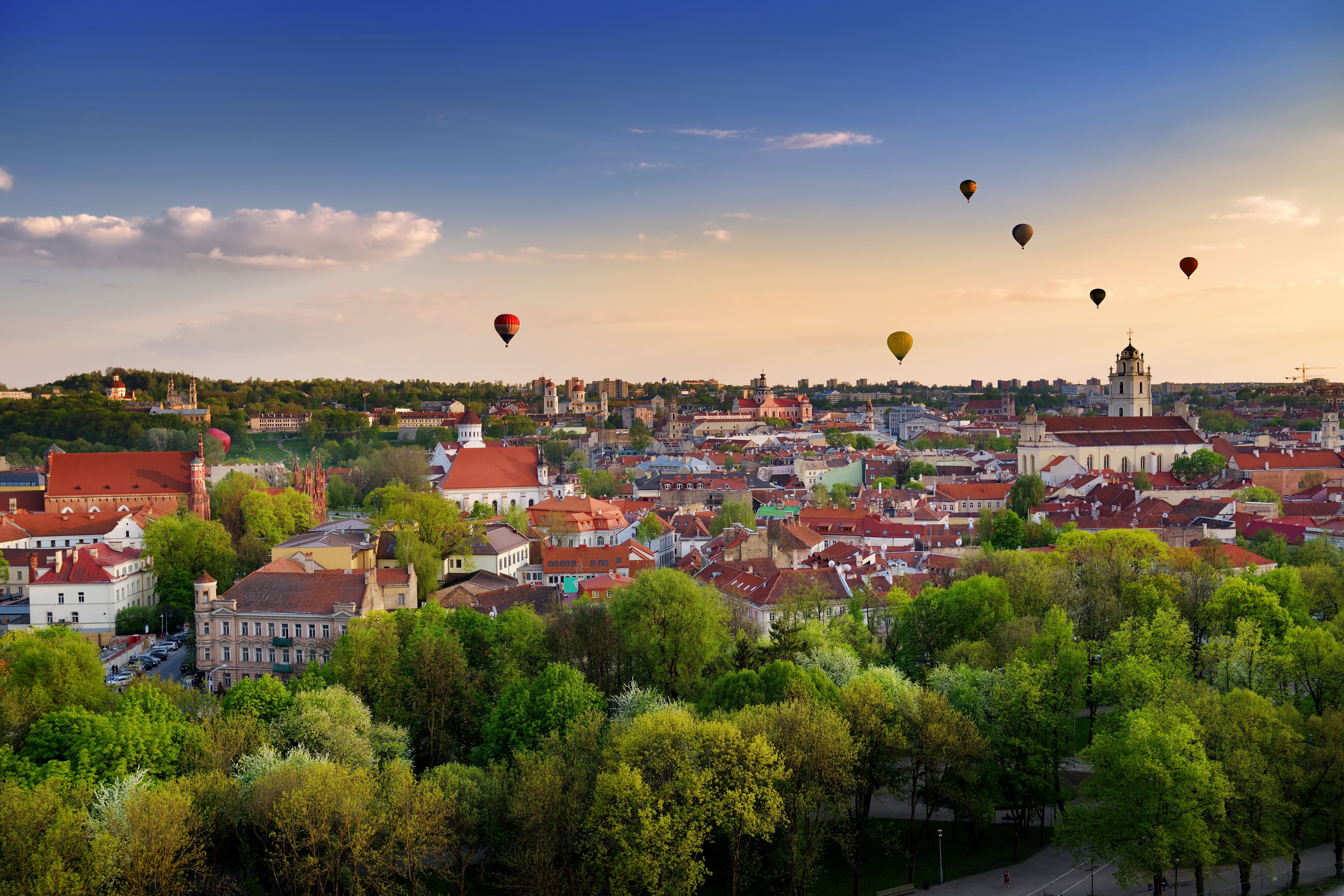 Panorama of Vilnius old town with colourful hot air balloons in the sky