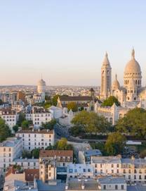 An aerial view of the Sacre Coeur Basilica rising above the streets of the Montmartre district at sunrise