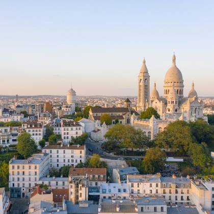 An aerial view of the Sacre Coeur Basilica rising above the streets of the Montmartre district at sunrise