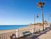View across a palm-tree-lined promenade on to the pristine sandy shores of La Cala de Mijas