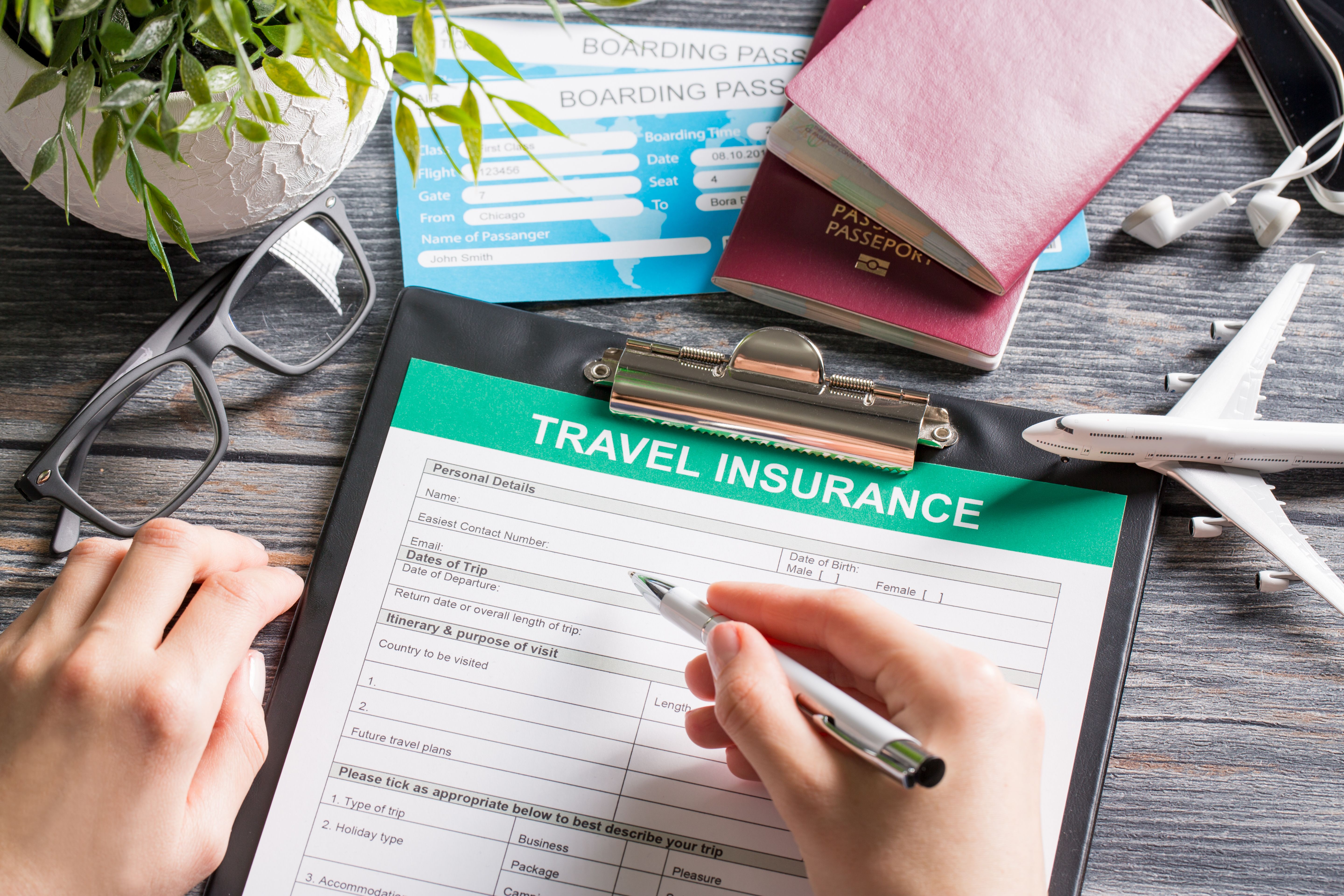 A travel insurance form on a table with passports and boarding passes