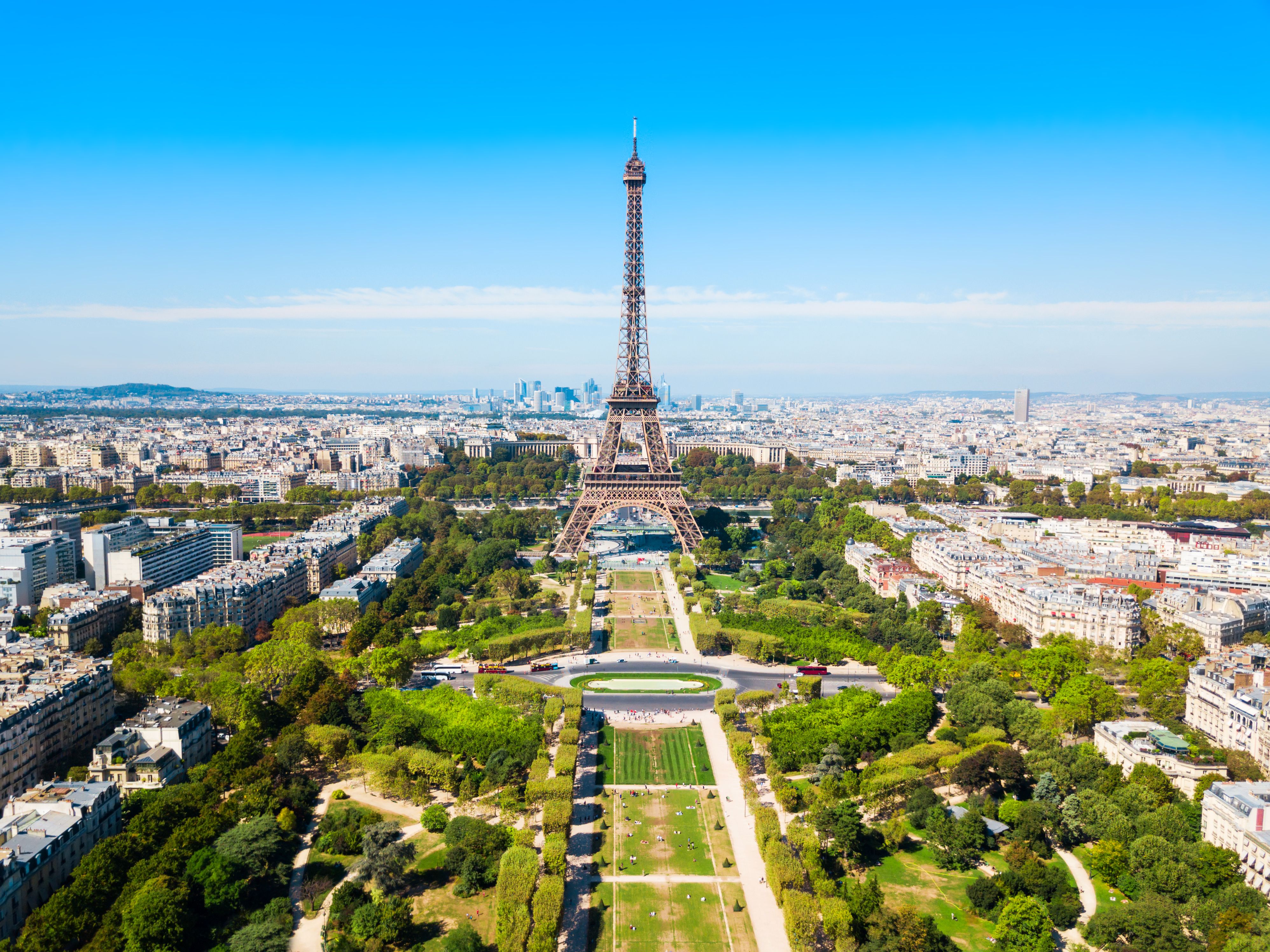 A view of the Eiffel Tower and Champ de Mars in Paris on a bright blue day