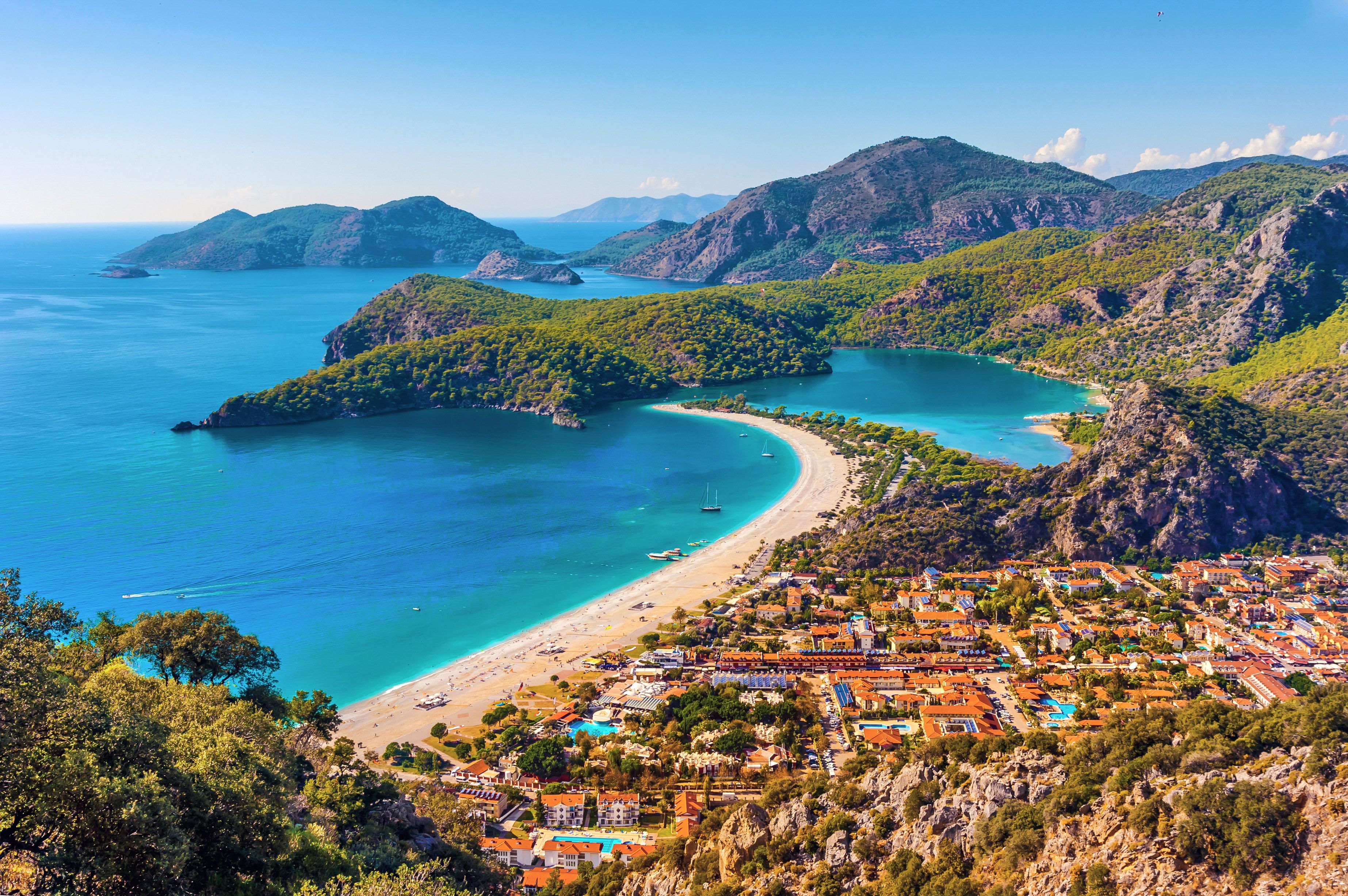 An aerial view of Oludeniz beach and lagoon in Turkey on a clear blue day showing the beach, sea, sand and village