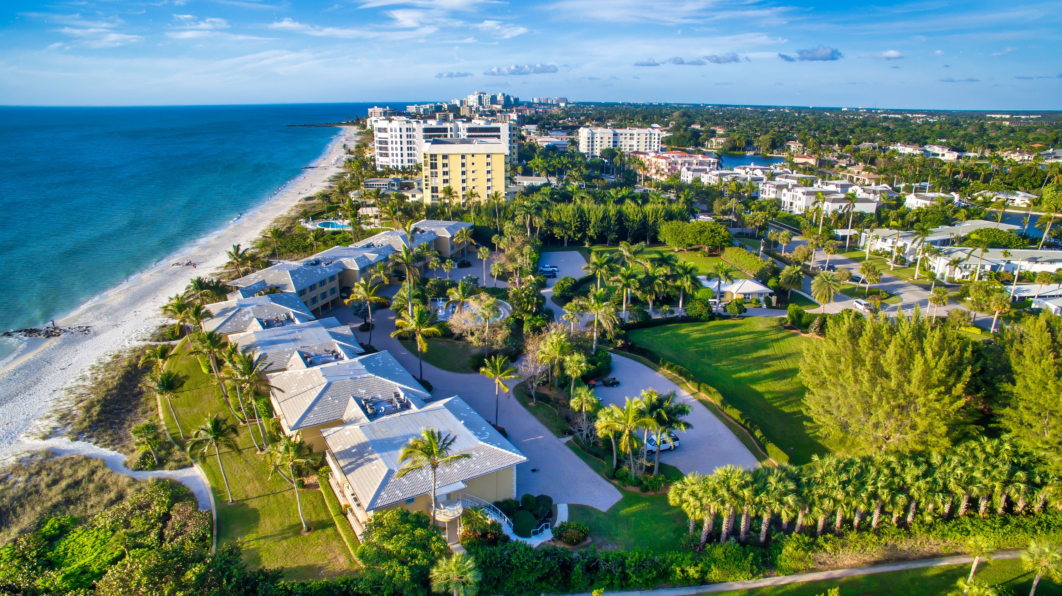 Panoramic aerial view of a beautiful city beach, low-rise hotels and green spaces