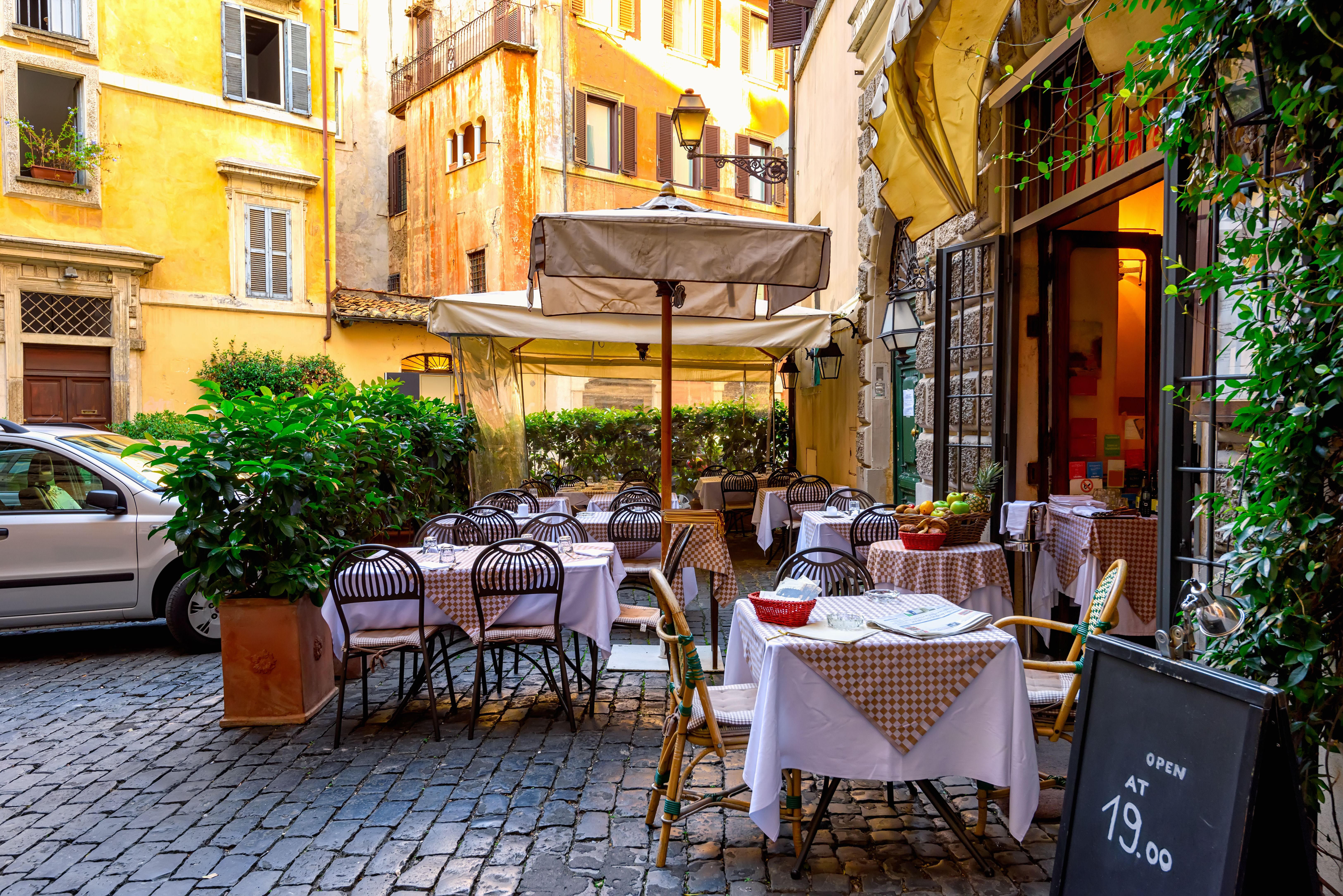 Outdoor tables and chairs at a courtyard restaurant in Rome, Italy