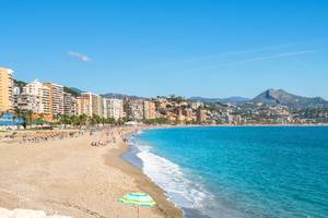 View of the golden sands and turquoise waters of Malagueta city beach in Malaga