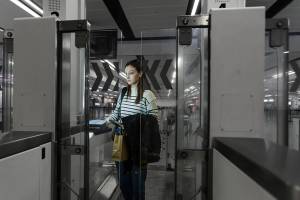 Woman standing at electronic gates at passport control in an airport