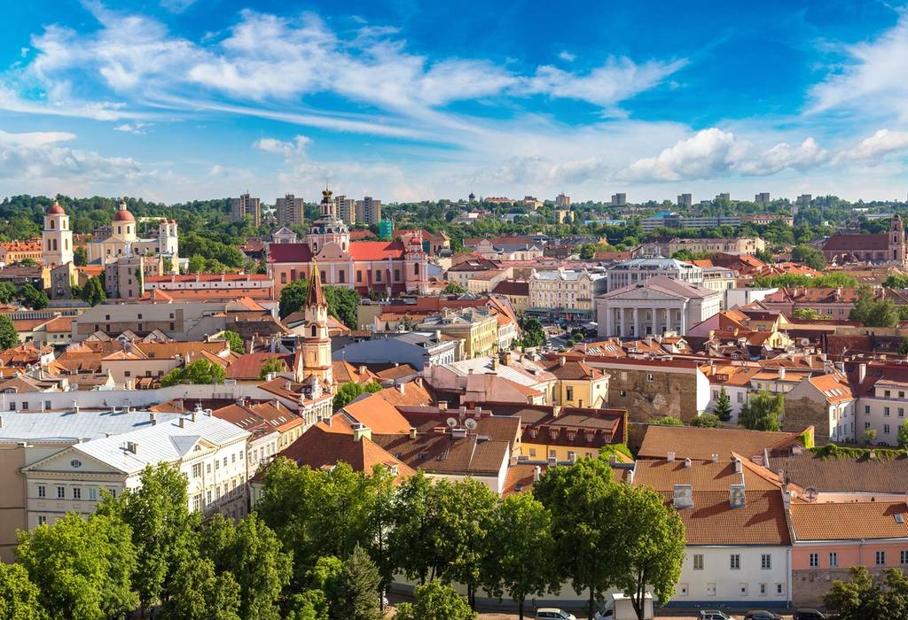 An aerial city view of Vilnius in Lithuania with colourful buildings and green trees on a summer's day