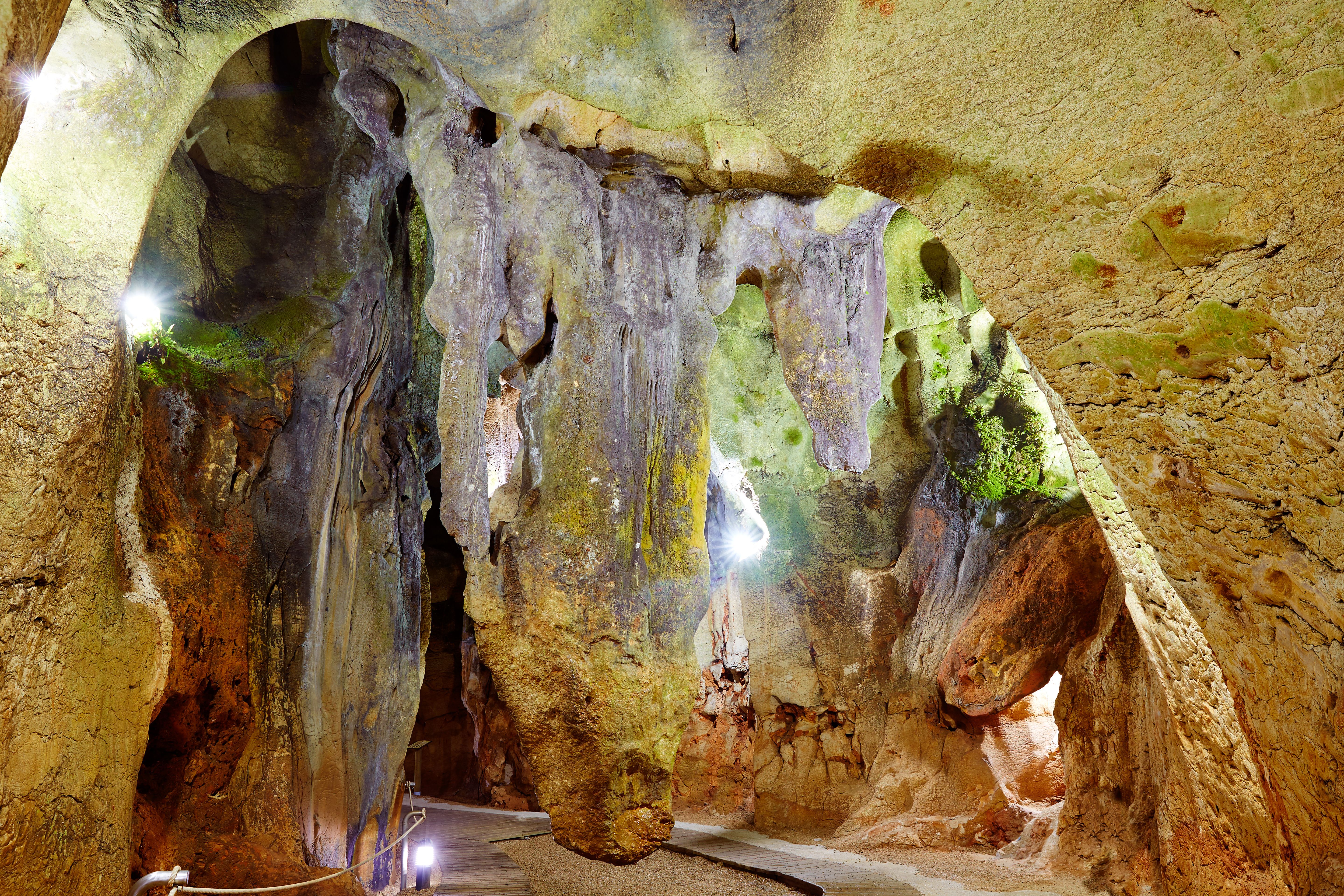A view inside Benidoleig Caves near Alicante in Costa Blanca with towering rock formations lit up by wall lights