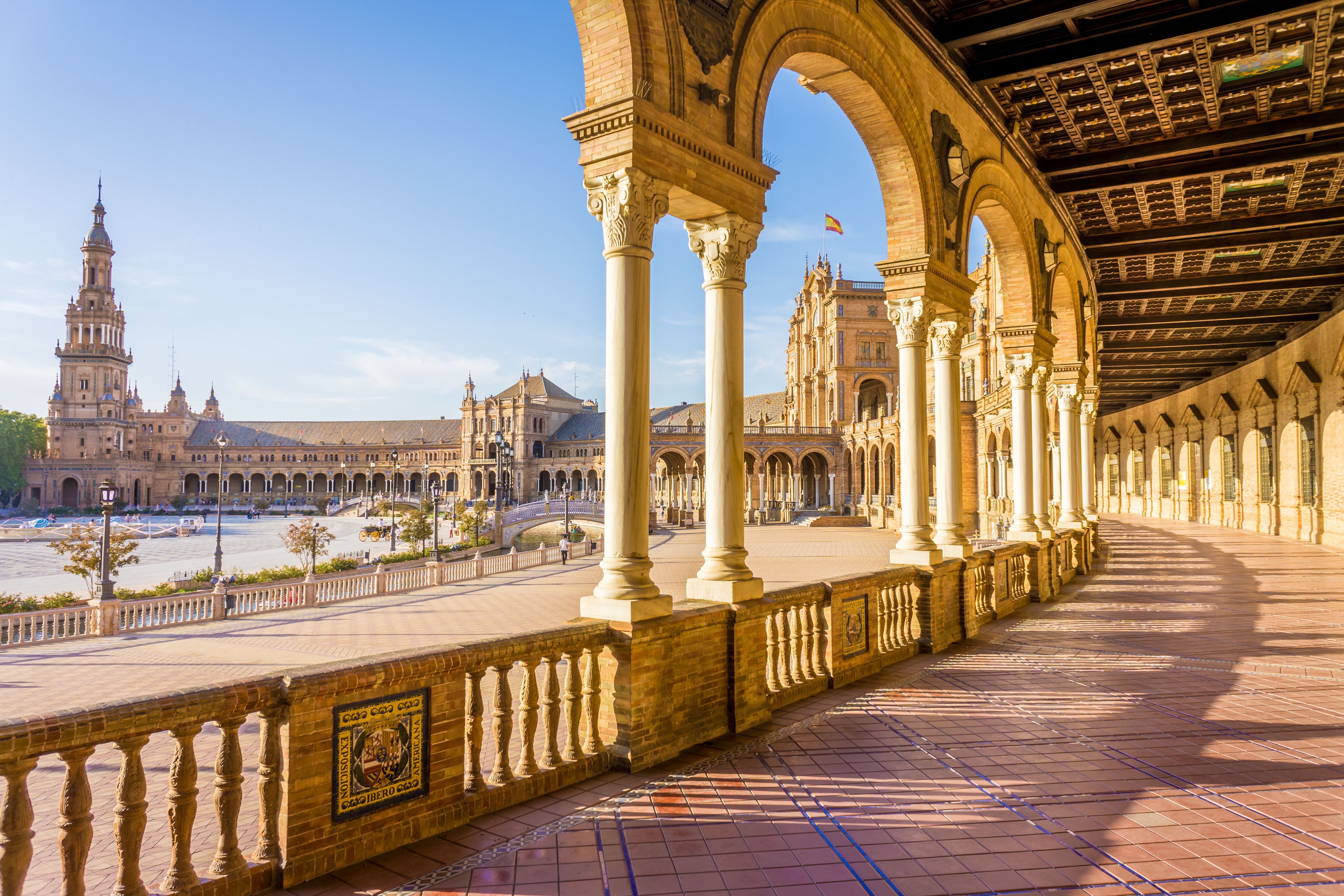 Light streams through the arches and columns of the honey-hued semi-circle Plaza de Espana building