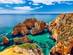 Aerial view of the Ponta da Piedade sea cliffs in Lagos, the Algarve, with motor boats exploring the caves