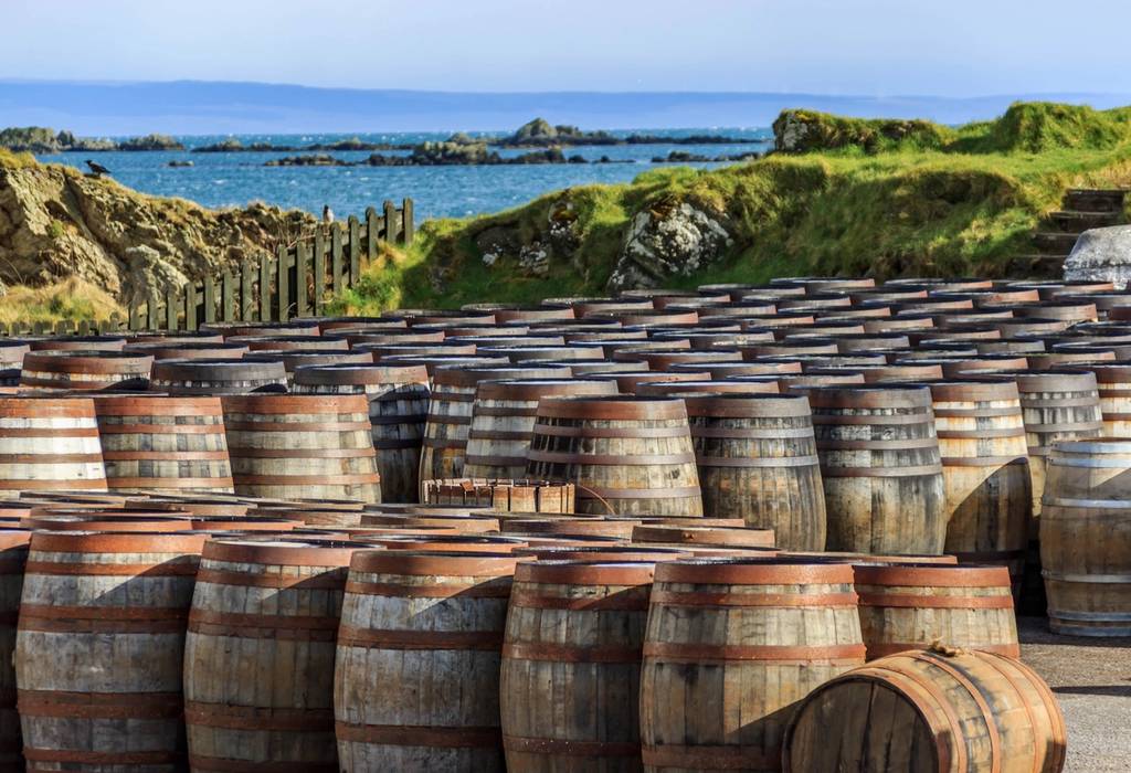 A view of Scotch whisky barrels lined up by the seaside on the Island of Islay in Scotland