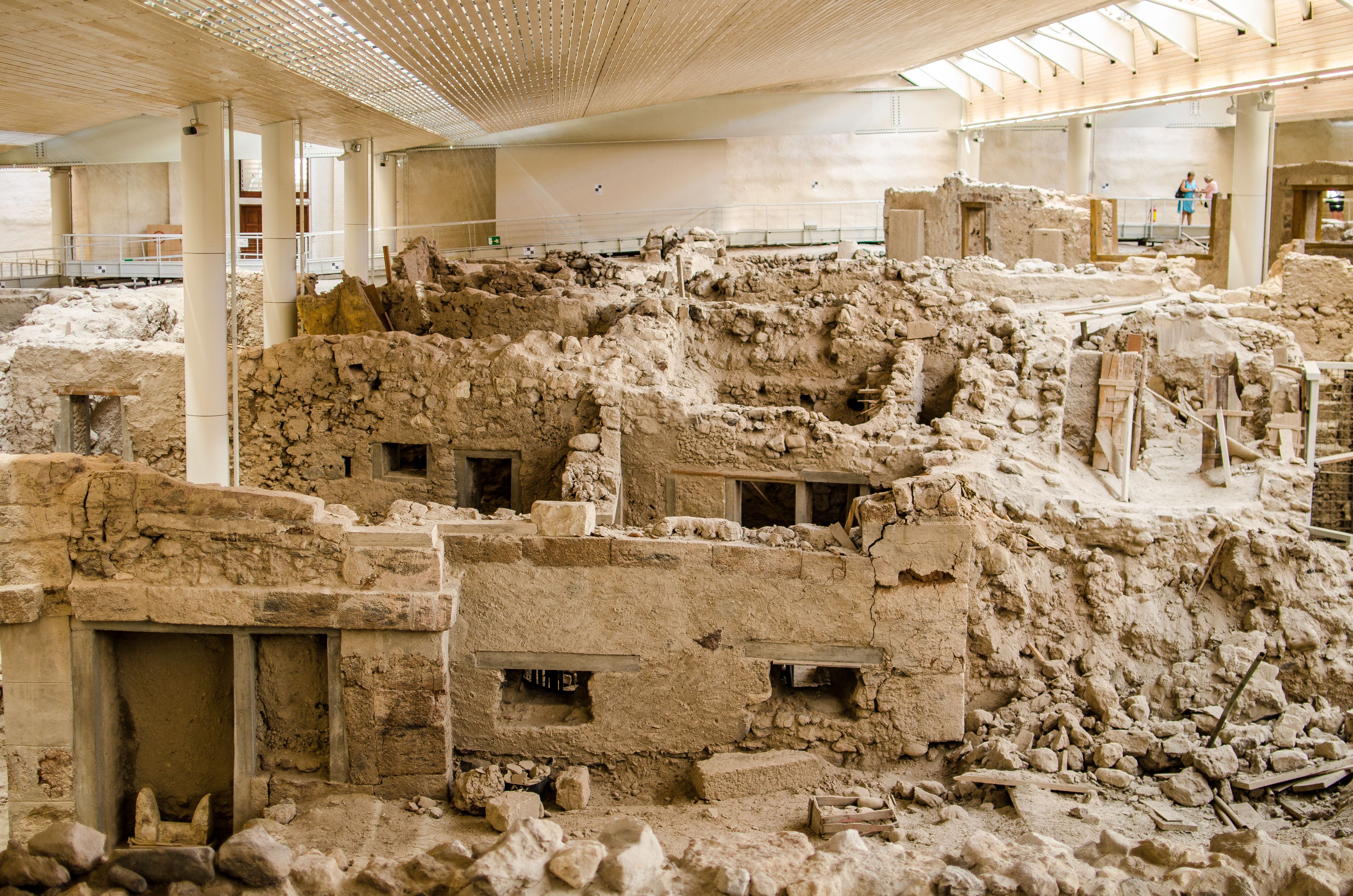 Crumbling clay ruins of a prehistoric town covered by a modern beige-coloured roof