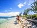 Two horse-riders walking along the sand on a tropical beach in the Cayman Islands, the Caribbean