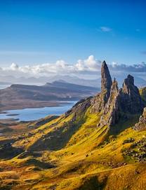 A sunset panorama of a dramatic rocky pinnacle known as the Old Man of Storr with lochs, seas and islands spreading out across the photo