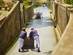 Toboggan riders pushing wooden sledge with tourists downhill - a famous tourist activity in Funchal, Madeira