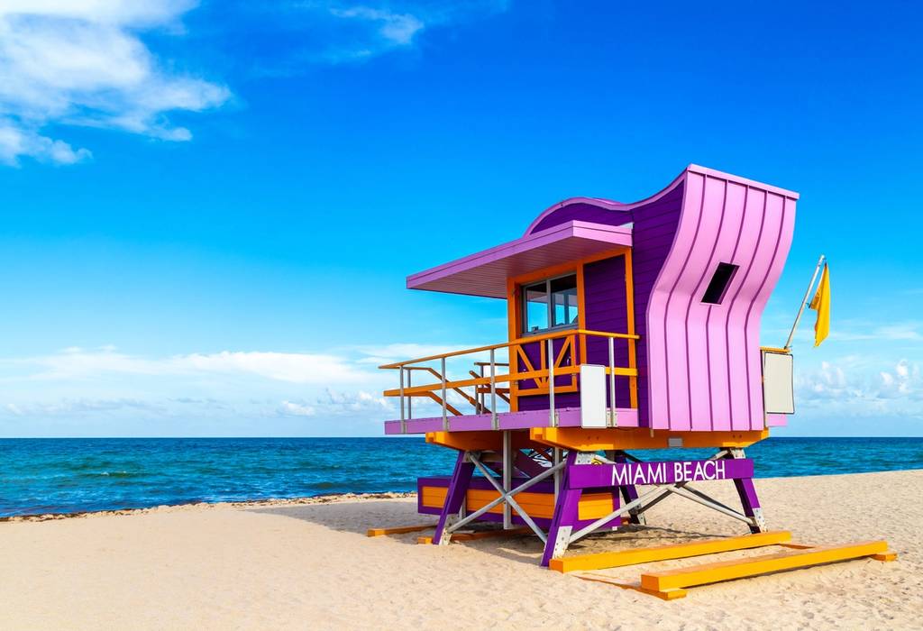 Purple and orange lifeguard hut on Miami Beach's golden sands on a sunny day