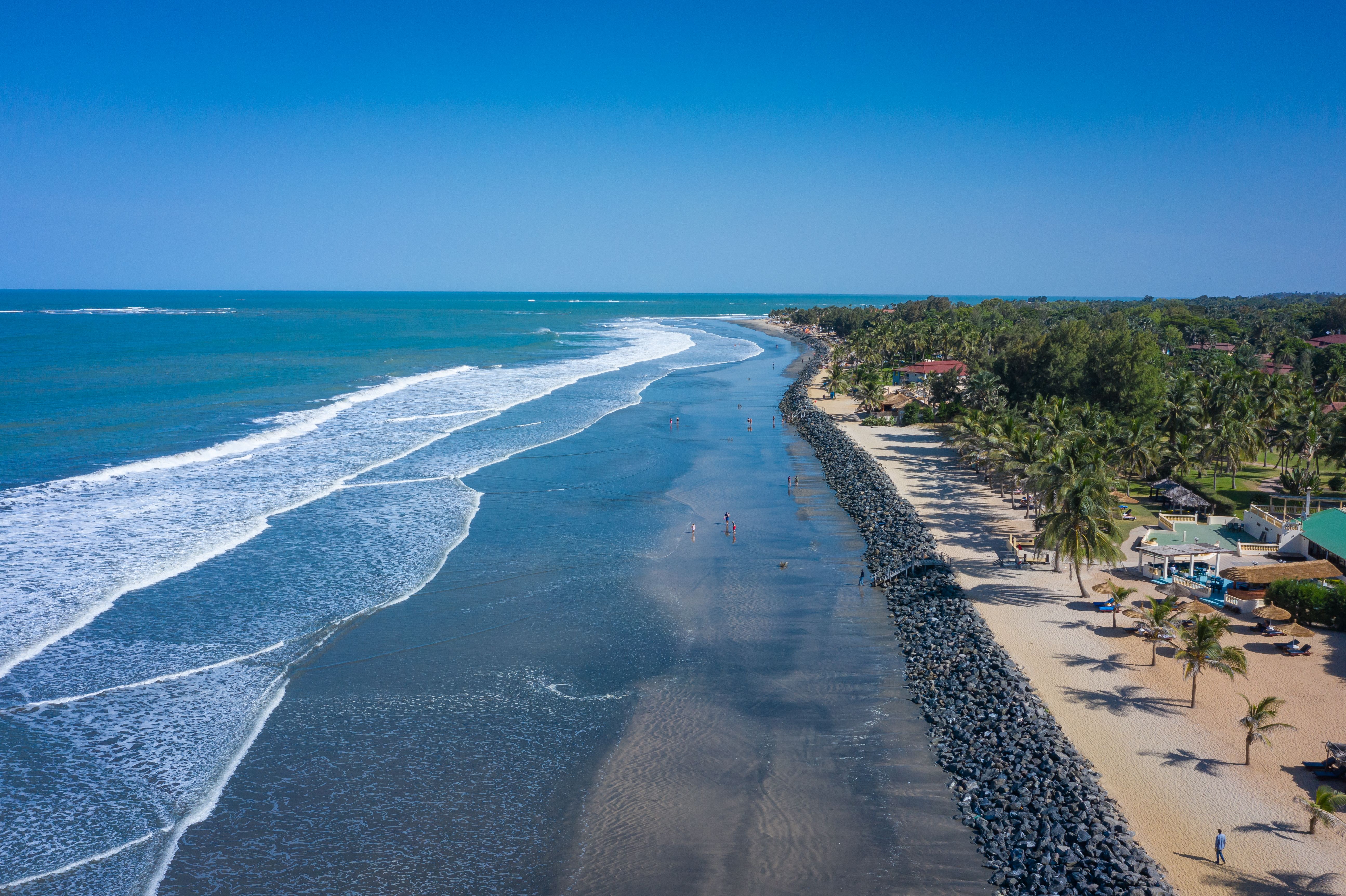 Aerial view of a palm-fringed beach in the Gambia.