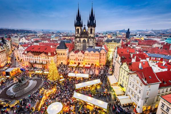 Aerial view of Christmas markets and tree in Prague's Stare Mesto old square, with Tyn Church towering over the scene