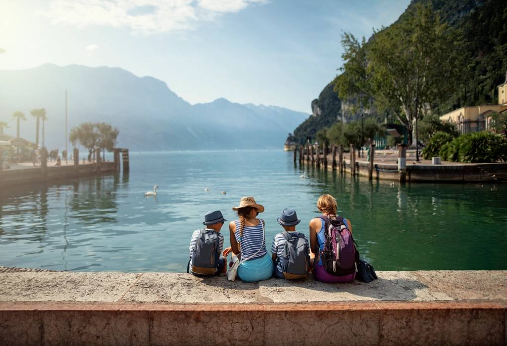 View of a family of four sitting along a harbour in Lake Garda, Italy