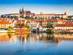River view of Prague city on a bright day with Praha Castle in the distance