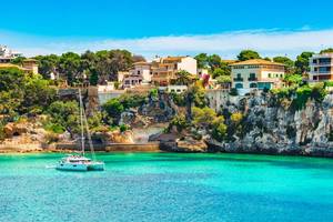 Beautiful view of bay with sailing boat and villas at the seaside of Porto Cristo on Majorca, Spain