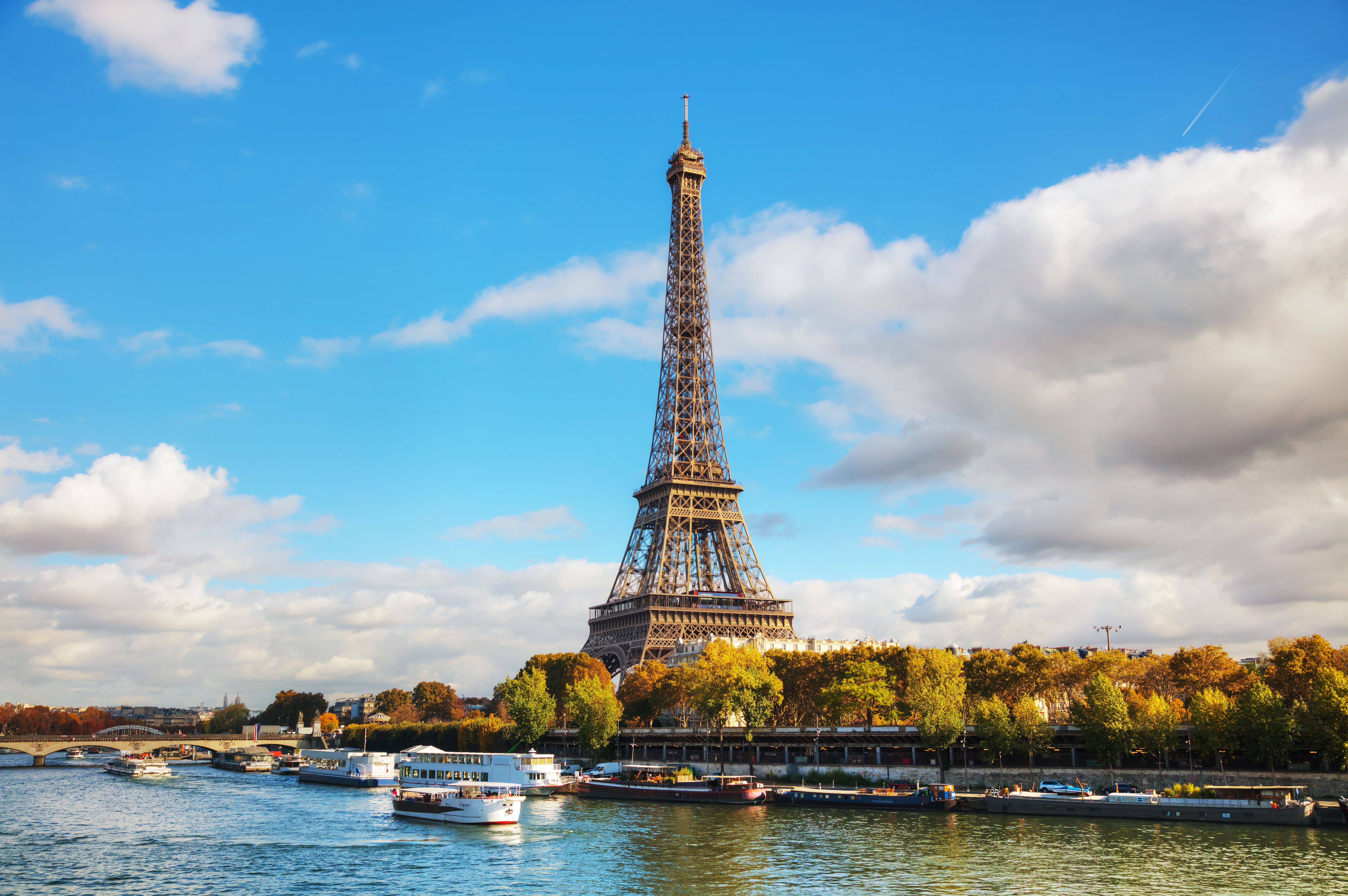A view of the Eiffel Tower and River Seine in Paris on a cloudy blue day