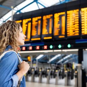 Female traveller at the airport looking at the arrival and departure boards