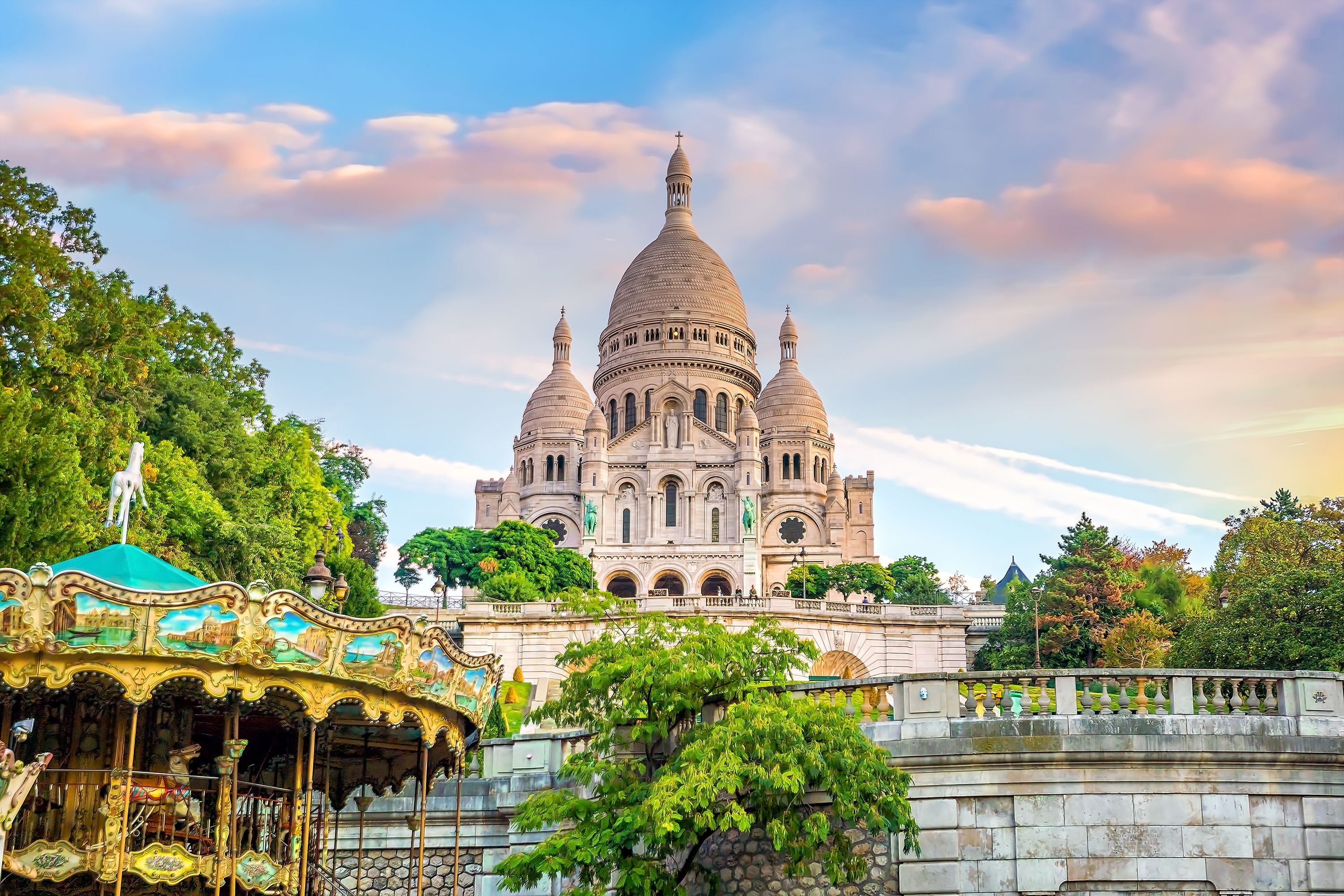 Pinkish clouds and skies over Paris' Sacre-Coeur Basilica and the Carrousel de Saint-Pierre