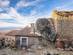 View of a stone house wedged underneath a huge boulder in a traditional Portuguese town.