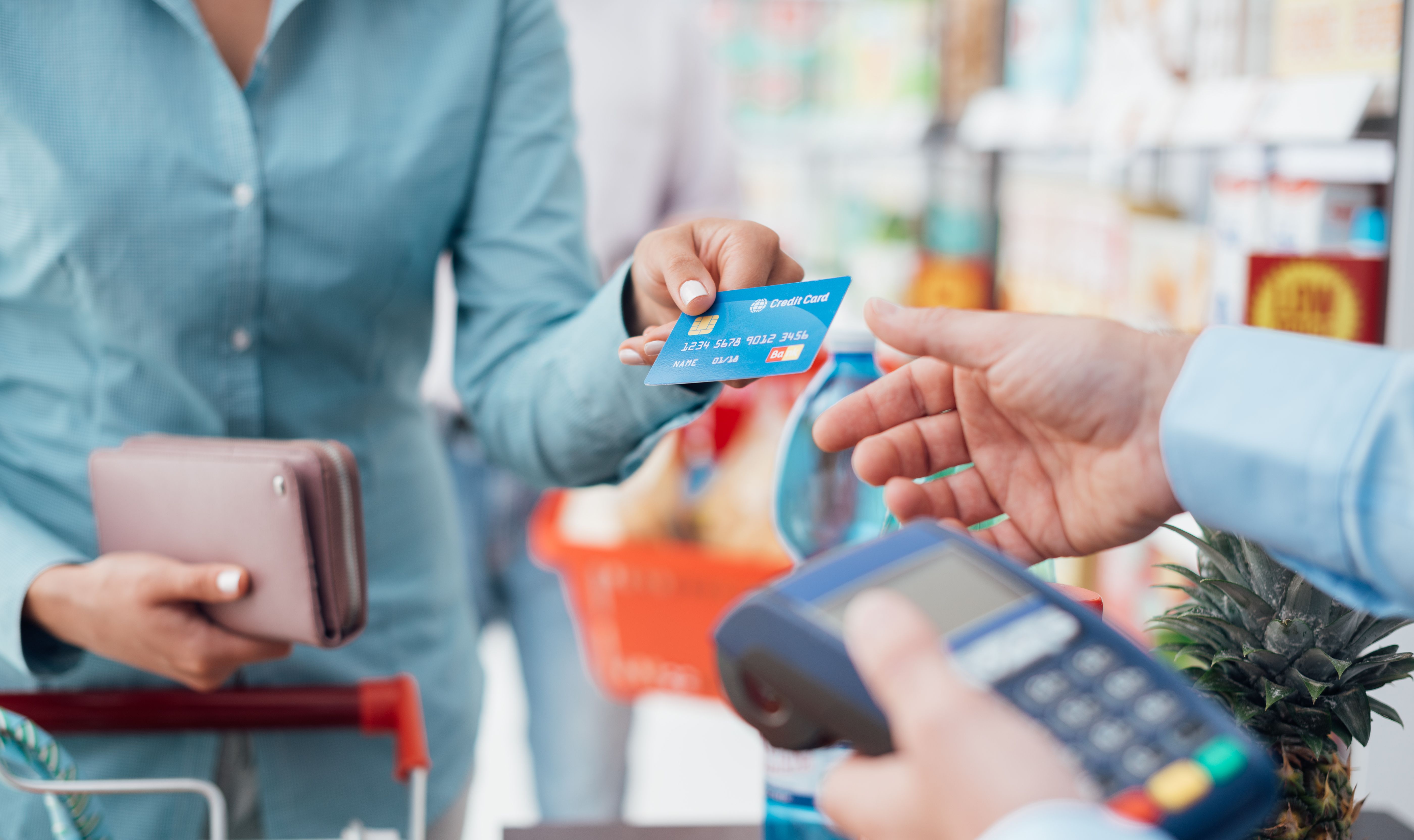 Woman handing over a credit card at a desk
