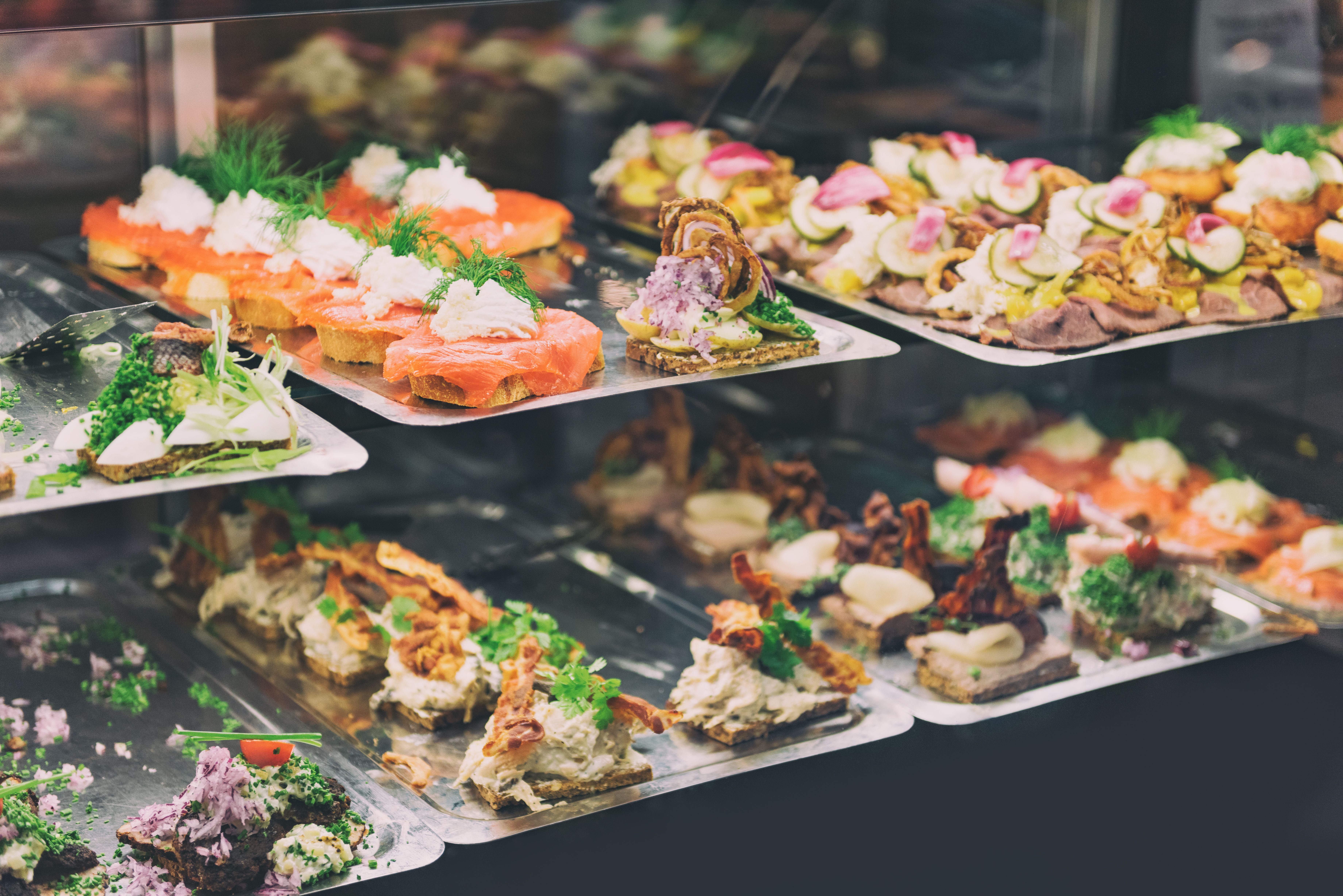 A food market stall displaying traditional Danish smorrebrod (open sandwiches) in Copenhagen