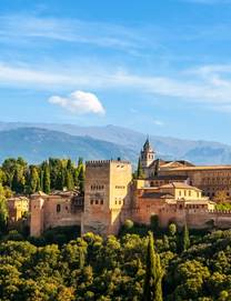 Aerial view the Alhambra Palace in Granada rising from among the trees with the Sierra Nevada mountains in the background