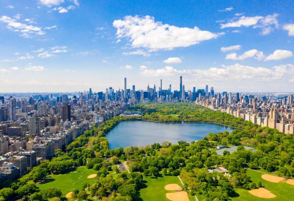 Aerial view of Central Park in New York with golf fields and tall skyscrapers surrounding the park