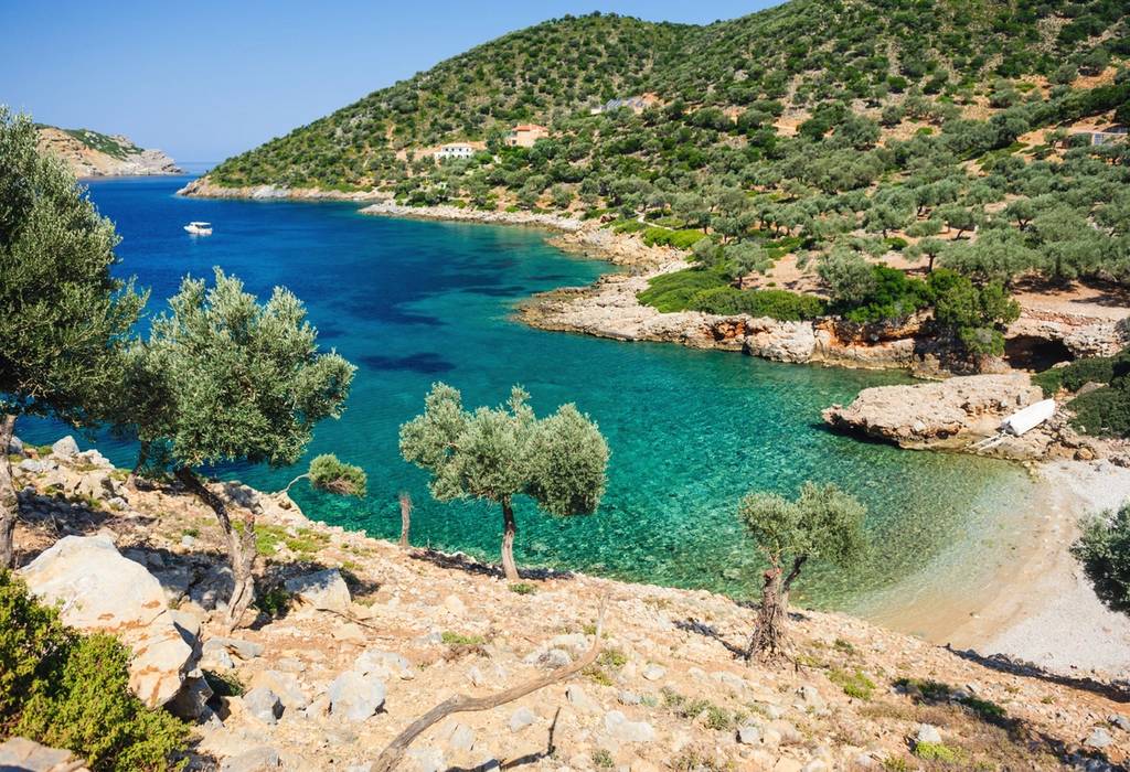 A picture of Agalou Laka beach on the west side of the Greek island of Alonissos located in the Aegean Sea with rugged landscape and beautiful sandy beach and clear water