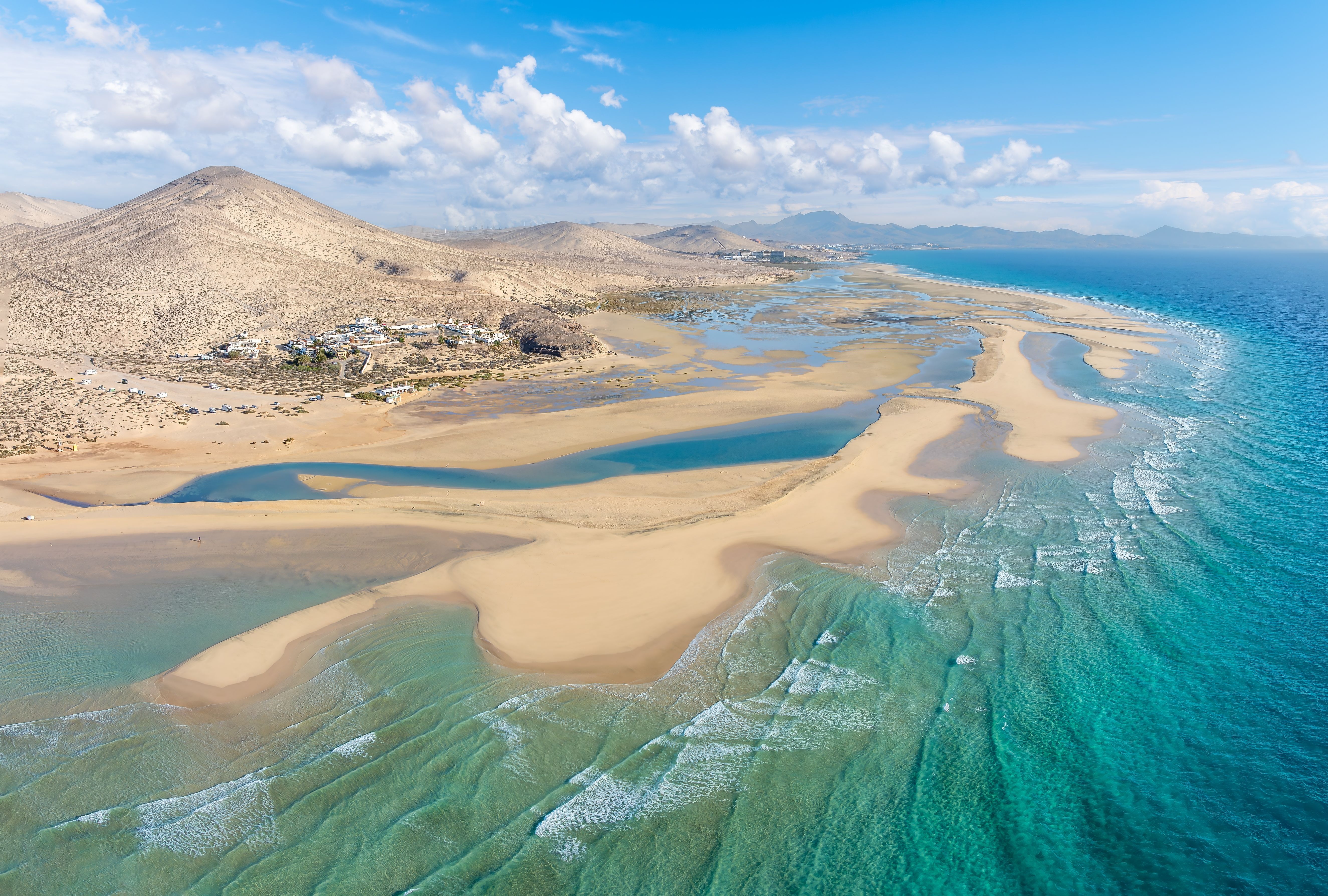 Aerial view of crystal-clear lagoons and sweeping sand dunes on Playa de Sotavento, Fuerteventura.